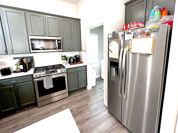 Kitchen features a gas burning stove and double-door stainless steel refrigerator that comes with the rental.