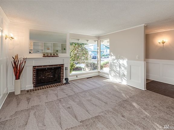 Bright living room with beautiful wood fireplace. New carpet and interior paint throughout home.