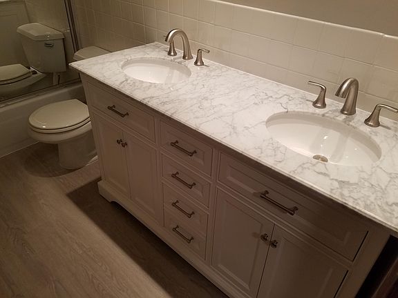 Renovated upstairs bath includes new wood floors and high end custom vanity with marble top, dual his and her sinks and soft close doors!