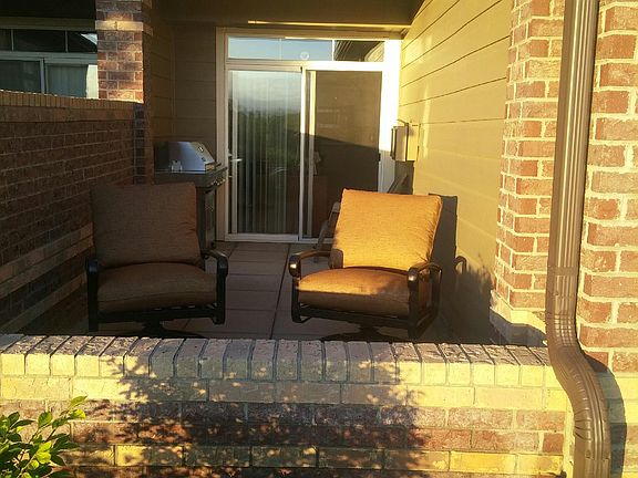 Patio with gas BBQ and storage bin for chair cushions.