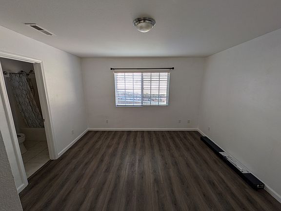 Shot of the room standing at the closet, showcasing the window and back side of the room.