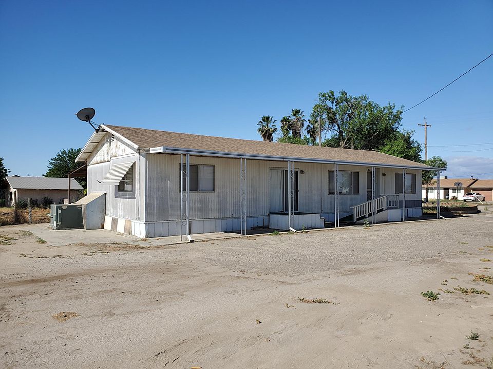 Outside of home. Shaded carport in the backside.