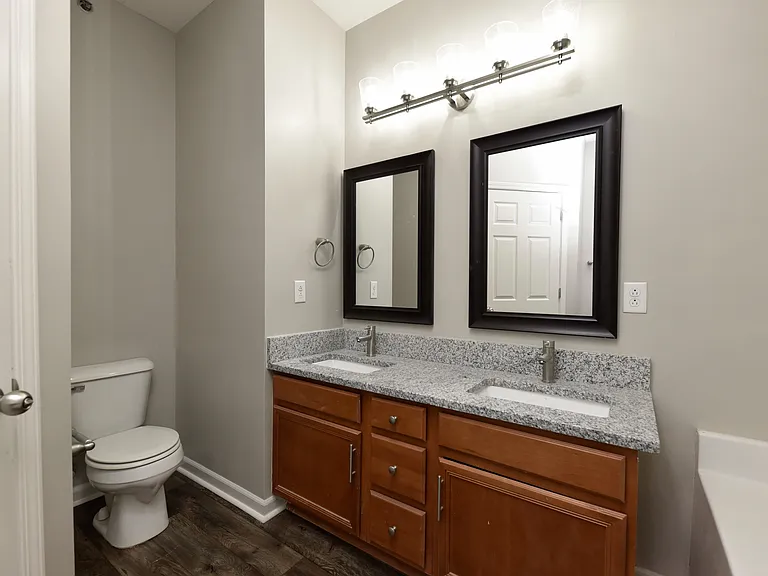 Bright bathroom with granite counters and double sinks