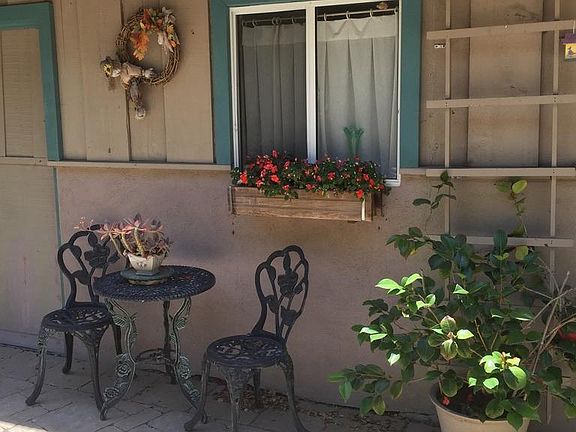 View of front patio with flower box and window in add-on room