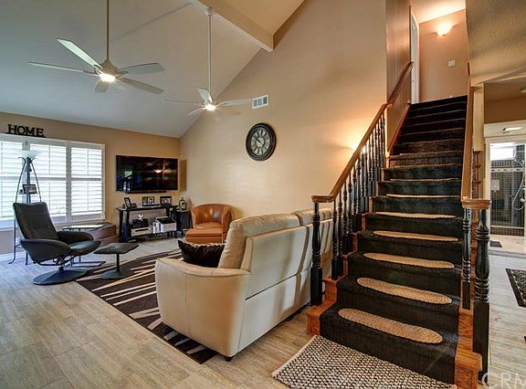 Living room with ceiling fans, plantations shutters and sliding doors to rear yard.