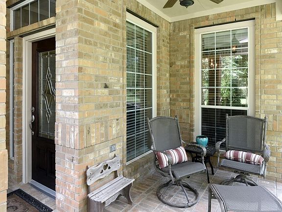 Delightful front porch overlooks beautifully landscaped front yard.