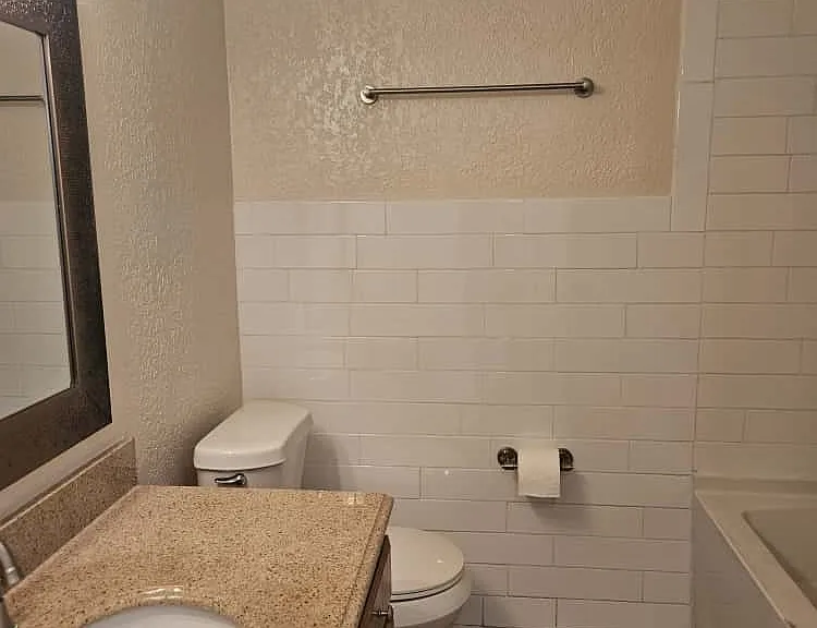 Bathroom featuring a wood vanity with granite countertop, updated lighting, and new fixtures.