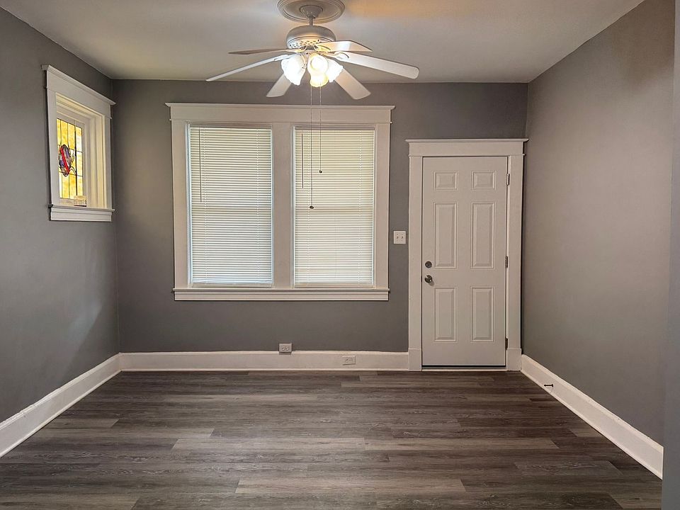Ceiling fan and natural lighting in living room, stained glass windows to left