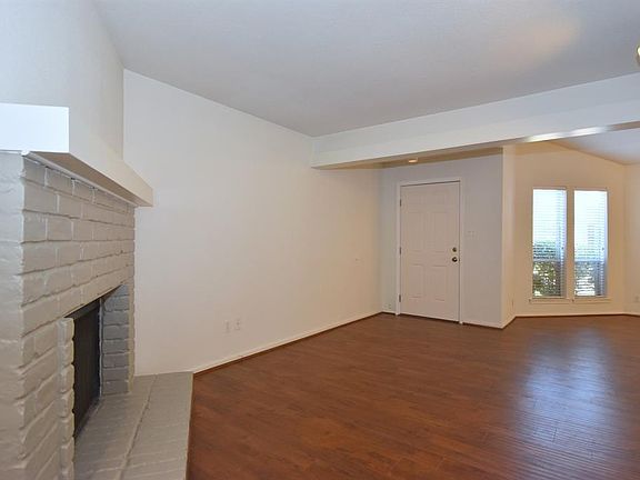 Enter through front door onto hand scraped flooring into the living space accented with a corner wood burning fireplace.