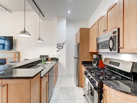 Designer kitchen with maple cabinetry & ample granite counters