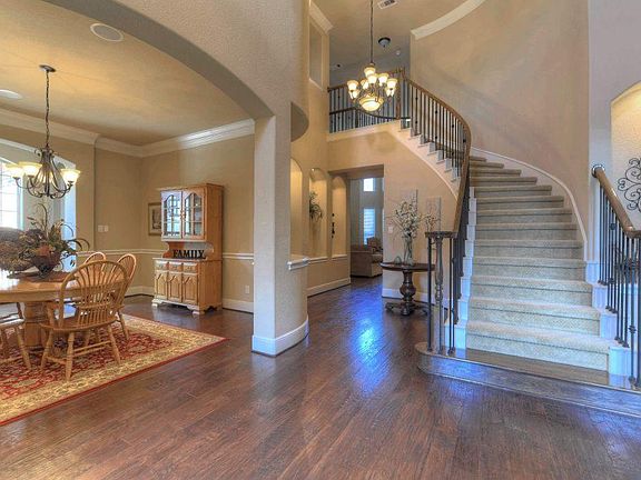 Greet your most discriminate guests in style in the breathtaking 2-story foyer, which boasts gleaming hardwood flooring, a beautiful leaded glass door, & a gorgeous winding iron staircase.