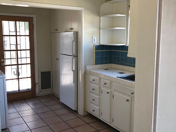 Kitchen with gas stove, pantry and open shelves.
