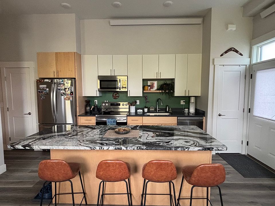 Kitchen with full size, counter-depth fridge, dishwasher, garbage disposal, microwave, oven. 8' granite countertop island with additional storage.