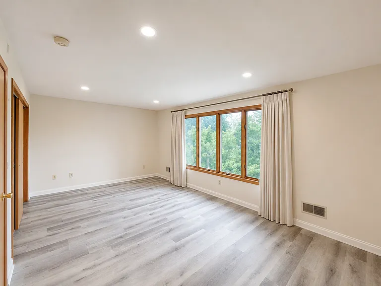 Bright and spacious primary bedroom with modern flooring
