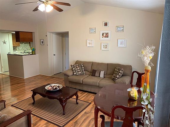 Check out those gorgeous laminate floors and high ceilings! This view is from the balcony door on the opposite side of the room from the front door. It looks onto the kitchen area and front door. The door on the left by the kitchen area is a coat clo