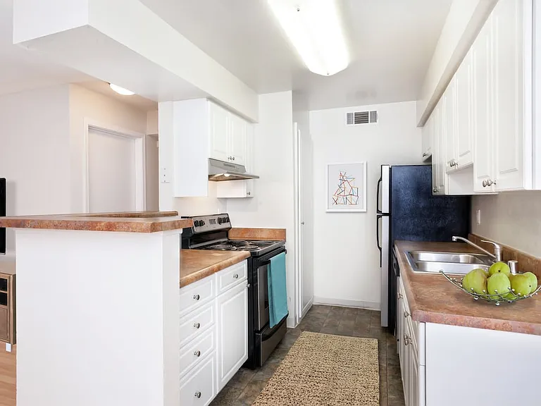 Classic Package II kitchen with white or metallic appliances, white cabinetry, and laminate countertops