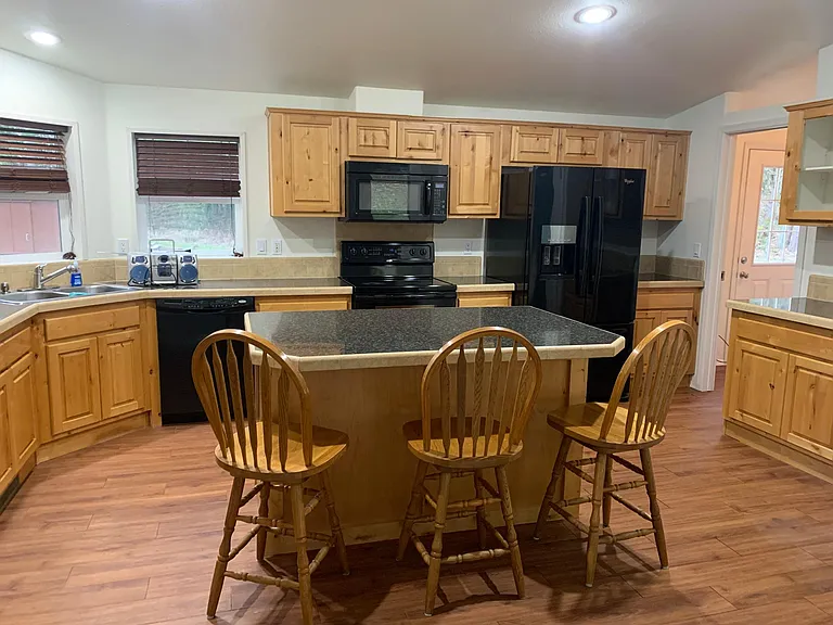 large kitchen with large island and ample cupboard space and pantry .