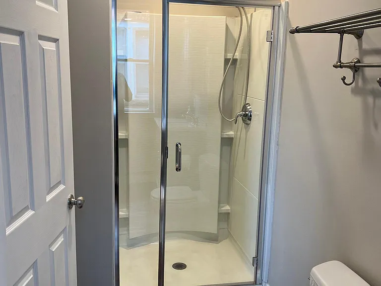 Shower with glass door and massaging water head