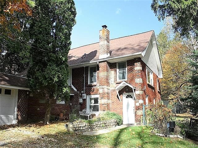 Enchanting brick & stone two story home with a storybook setting on close to 2 acres.
