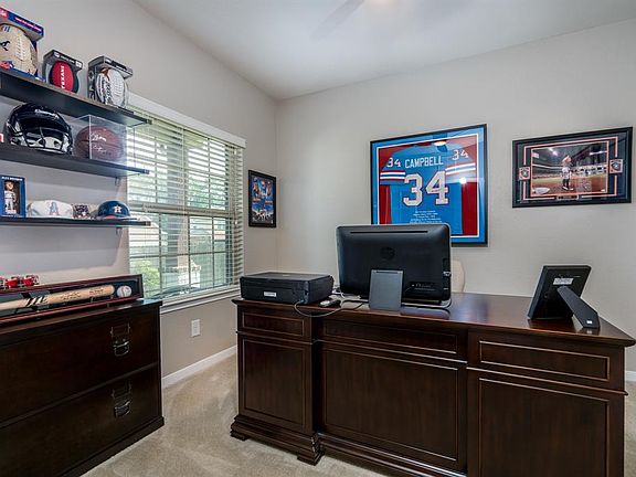 Behind double French doors is this private home office with views of the front yard!