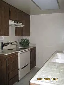 Kitchen has new stove and refrigerator close to patio and dining room.
