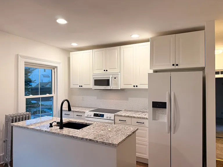 Refinished kitchen with granite, updated appliances, and fixtures.