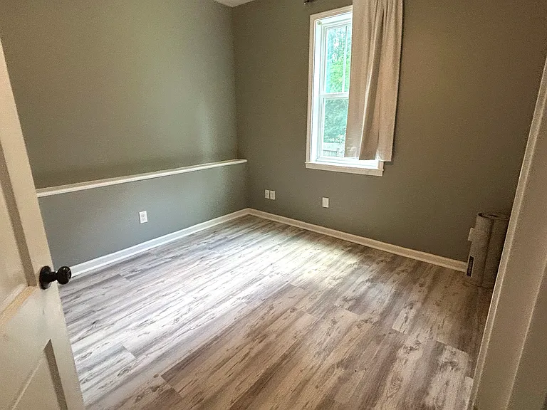 In bedroom 4, you'll find a shelf running along the length of the wall, blackout curtains, great lighting, and hardwood flooring throughout.