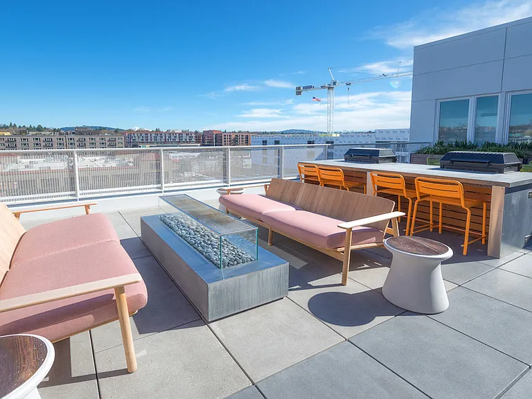 Rooftop lounge with fire feature and city views.