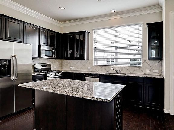 This stunning kitchen includes stainless steel appliances, a pantry, eat in island and a wine rack too!