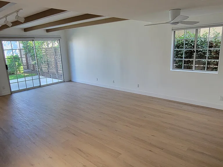 Family room with new flooring and ample lighting.