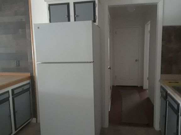 Newer fridge and hallway to masterbedroom