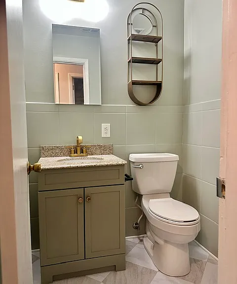 Newly renovated half bath that opens to the main bedroom and hallway.