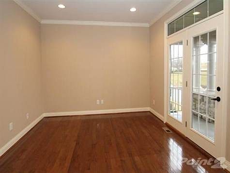 Parlour with gleaming hardwood floors, crown moldings, & strium door with transom leading to the covered patio.