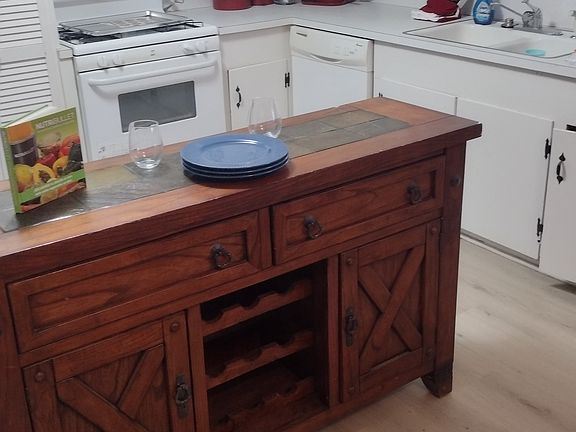 wine and serving table in kitchen. Light wood laminate flooring for easy clean. All appliances and utensils provided.