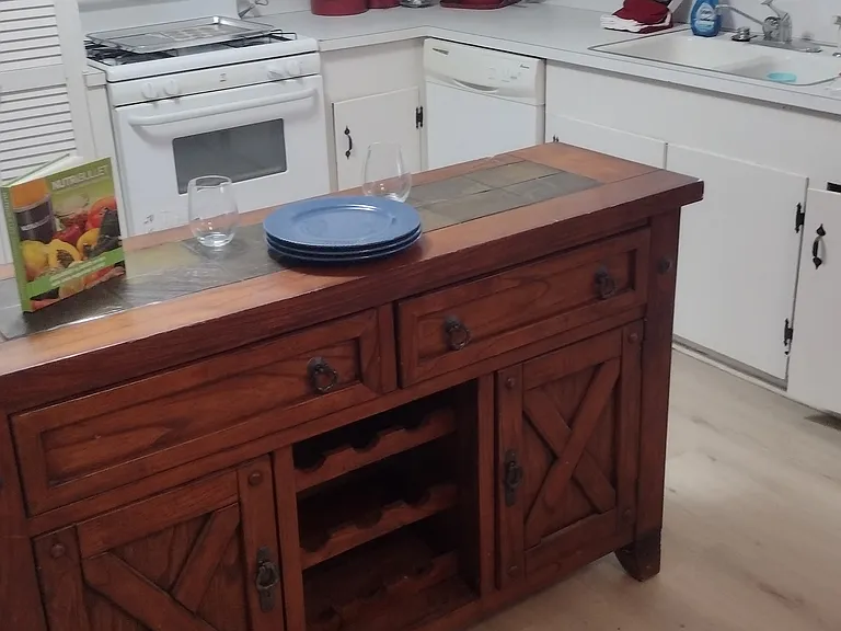 wine and serving table in kitchen. Light wood laminate flooring for easy clean. All appliances and utensils provided.