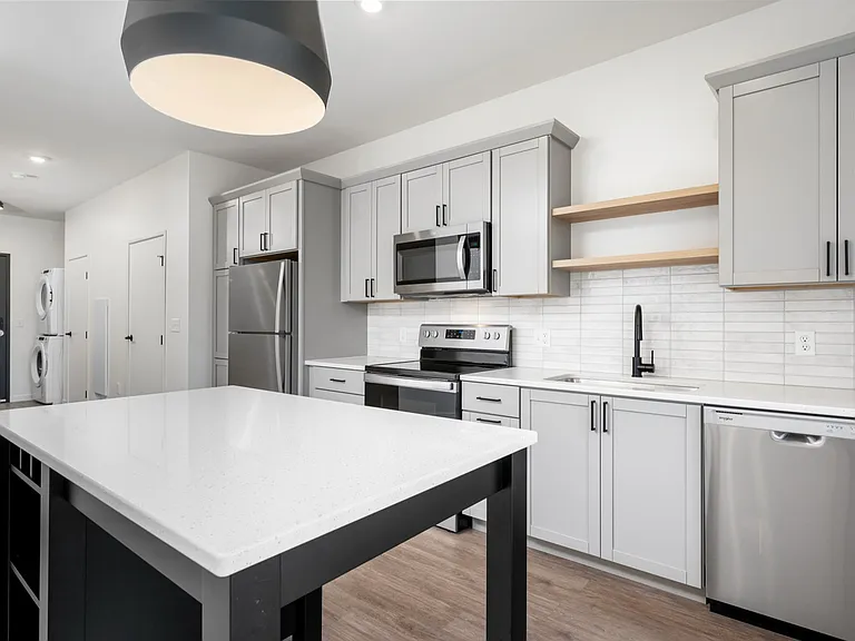 Sleek modern kitchen with stainless steel appliances, stylish gray cabinetry, and an elegant island centerpiece. Sleek modern kitchen with stainless steel appliances, stylish gray cabinetry, and an elegant island centerpiece.