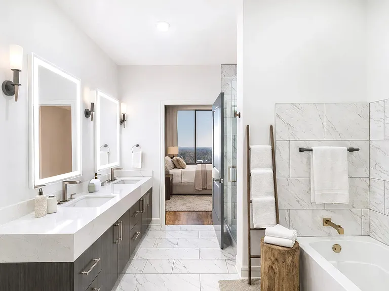 A penthouse primary bath defined by clean geometry, warm wood cabinetry, and layered stone finishes for a cohesive, modern look.