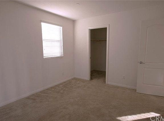 This photo shows the second bedroom, with a walk-in closet attached.