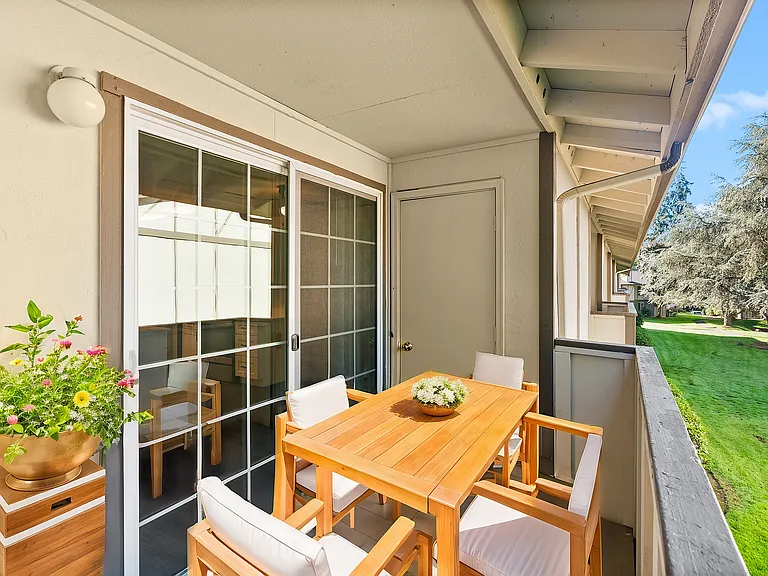 Step into a tranquil balcony space offering comfort and picturesque greenery views.