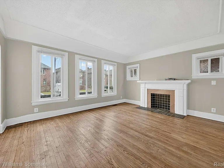 Bright, airy living room featuring hardwood floors and an electric fireplace insert