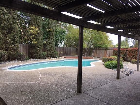Large private yard has covered patio as well as corner deck under large apricot tree.