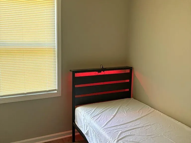 Private bedroom with a window and blinds, hard-surface flooring, and a mini-split AC for individualized comfort.