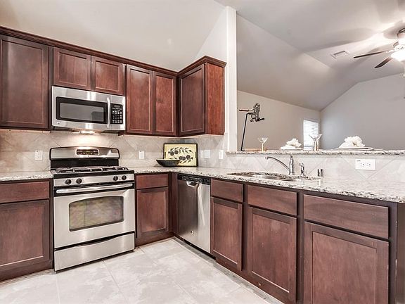 Kitchen with stainless appliances and granite countertops.