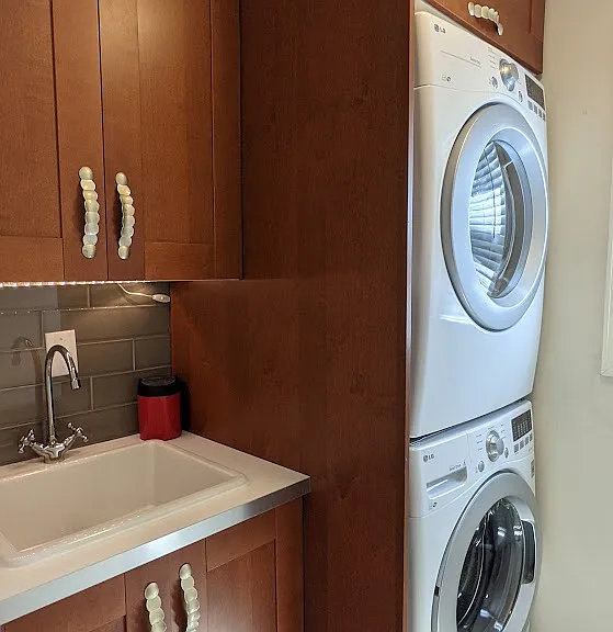 Separate washroom on ground floor with LG stackable washer dryer and mud sink.