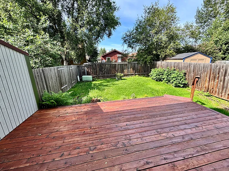 Large fenced-in back yard with beautiful deck.