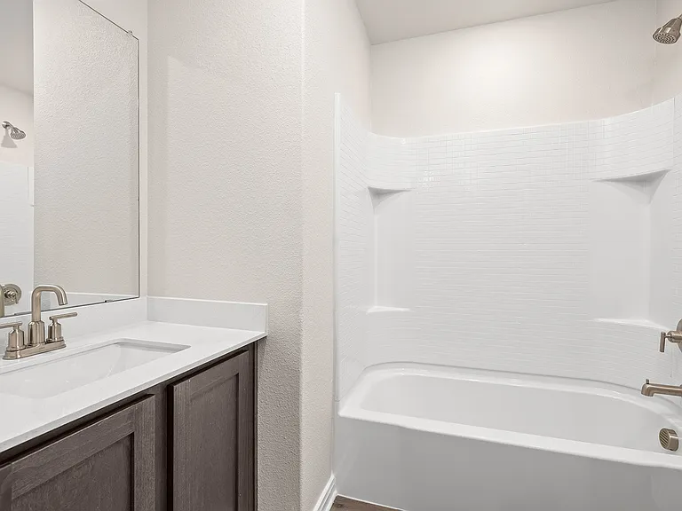 The secondary bathroom has a sprawling vanity and shower-tub combo.
