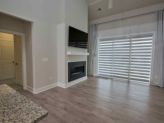 Great room with vaulted ceiling to the loft. Fireplace & a mounted 65" TV. 
Custom zebra blinds on the 9'x8' rear door & windows.