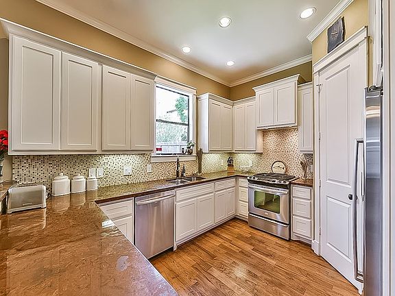 Granite counters and stainless steel appliances in this kitchen with gas range