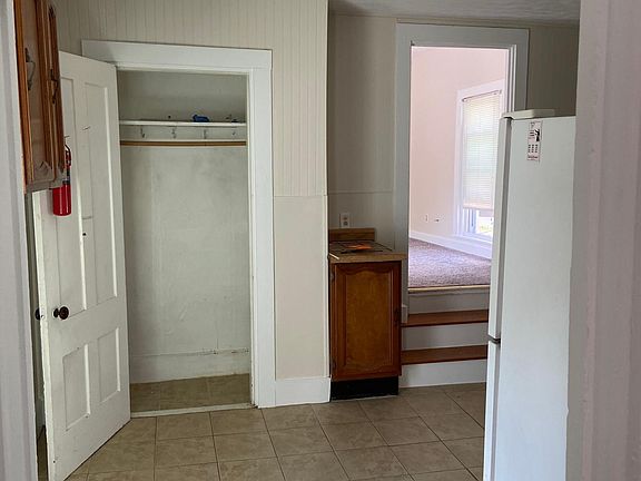 View from bedroom door into kitchen. All walls have a fresh coat of paint.