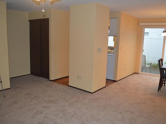 Partial living room looking into dining room and kitchen, coat closet to the left